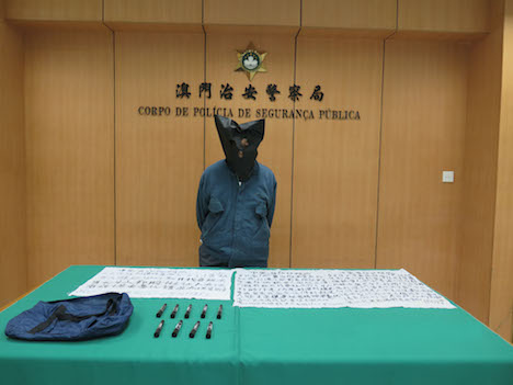 文化財などに落書きした容疑で逮捕された82歳の香港人の男と証拠品（写真：マカオ治安警察局）