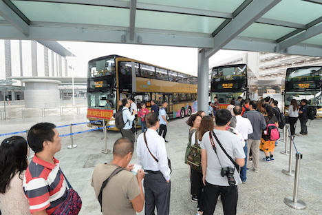 港珠澳大橋のマカオ側と香港側のイミグレーション施設と往来するシャトルバスに乗り込む乗客＝2018年10月24日、港珠澳大橋マカオ側イミグレーション施設内（写真：GCS）