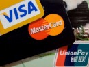 中国本土で広く普及する銀聯(右下)と二大国際ブランドのカード(資料)—本紙撮影