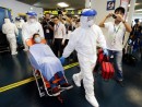 防護服を着た消防局員により外港フェリーターミナルから山頂医院へ搬送される患者役(写真:新聞局)