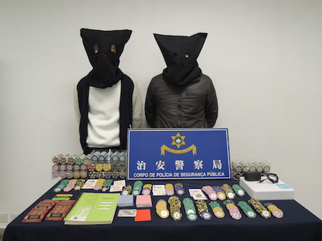 闇カジノを経営していたとされる被疑者2人と警察が押収した証拠品＝2月3日（写真：マカオ治安警察局）