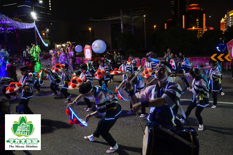 沿道に集まった多くの観衆に向かって花笠踊りを披露＝2月10日、マカオ科学館前—本紙撮影