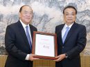 李克強中国国務院総理(右)から任命書を受け取る賀一誠氏(写真:GCS)
